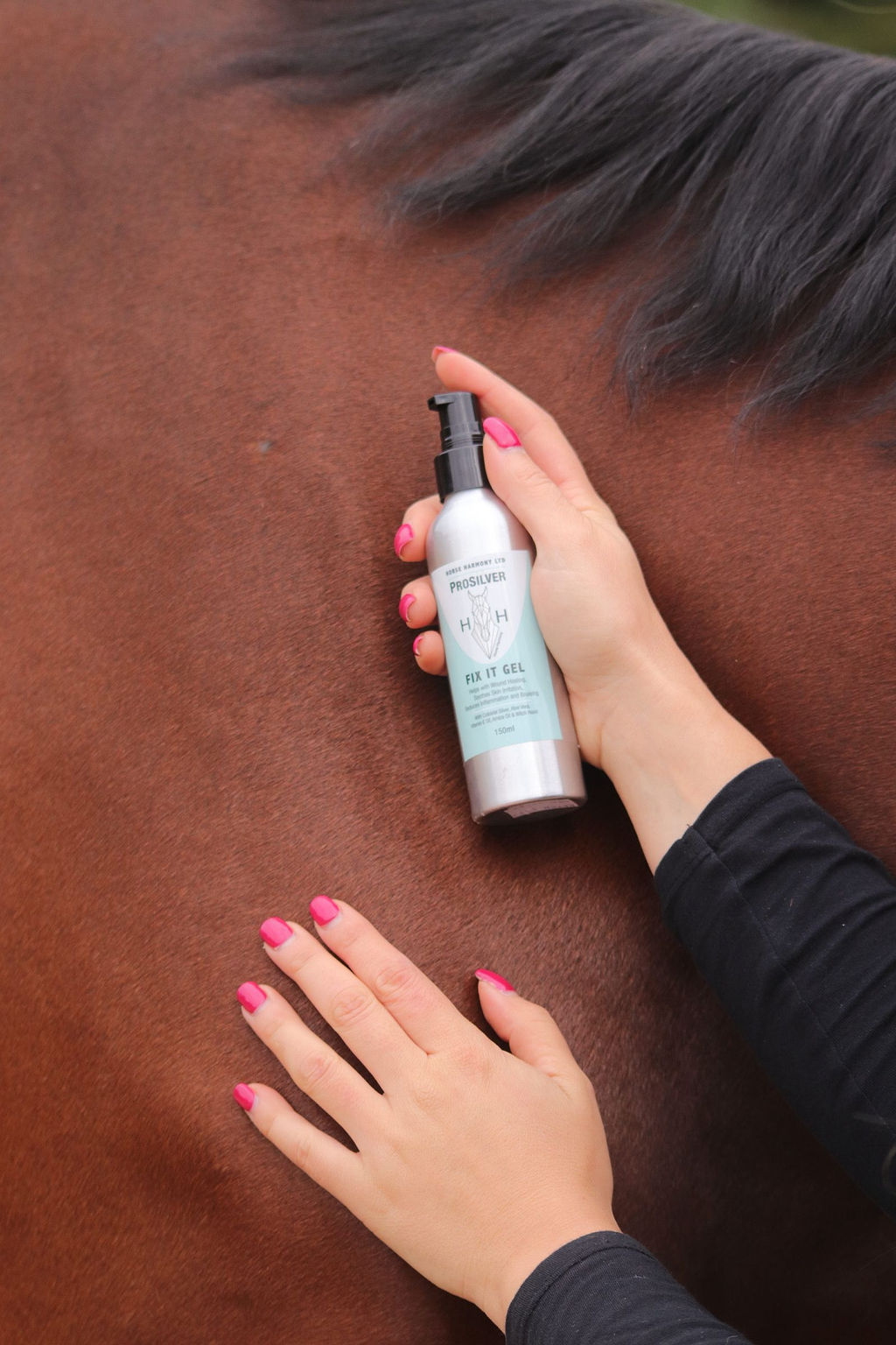 Person holding a bottle of Fix It Gel next to a grazed patch on horse's shoulder